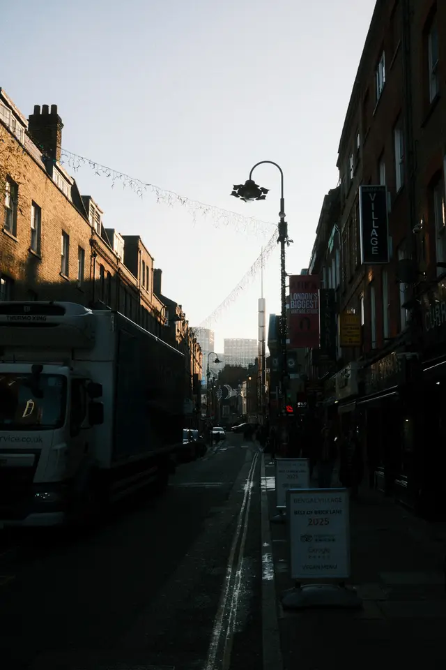 A busy London street with the Shard visible in the background against a pale winter sky