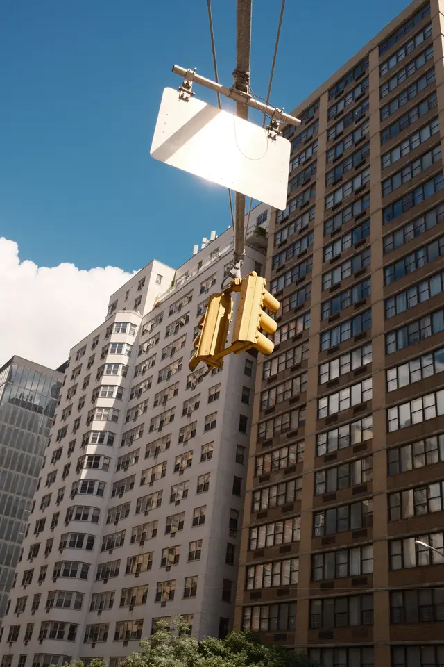 Yellow traffic lights hung against apartment towers and a clear blue sky